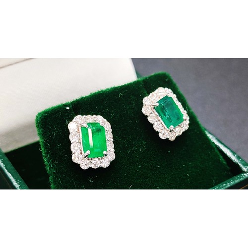 42 - EMERALD AND DIAMOND STUD EARRINGS, a pair, each with a central emerald cut emeralds surrounded by 14... 