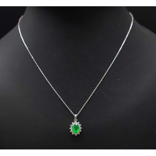 43 - 18CT WHITE GOLD EMERALD AND DIAMOND CLUSTER PENDANT, fitted on an 18ct white gold chain, the emerald... 