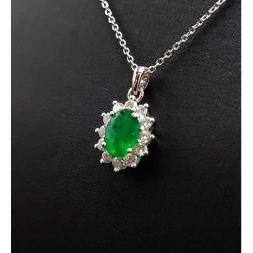 43 - 18CT WHITE GOLD EMERALD AND DIAMOND CLUSTER PENDANT, fitted on an 18ct white gold chain, the emerald... 