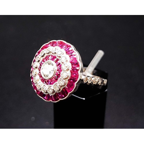 56 - PLATINUM RUBY AND DIAMOND COCKTAIL RING, with a central round brilliant cut diamond of approximately... 