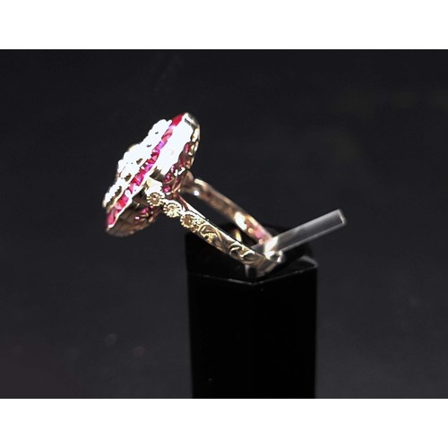 56 - PLATINUM RUBY AND DIAMOND COCKTAIL RING, with a central round brilliant cut diamond of approximately... 