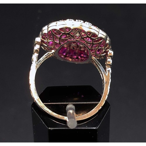 56 - PLATINUM RUBY AND DIAMOND COCKTAIL RING, with a central round brilliant cut diamond of approximately... 