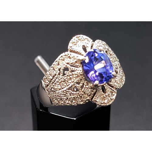 57 - PLATINUM TANZANITE AND DIAMOND SET DRESS RING, the oval tanzanite of approximately 1.52 carats, surr... 