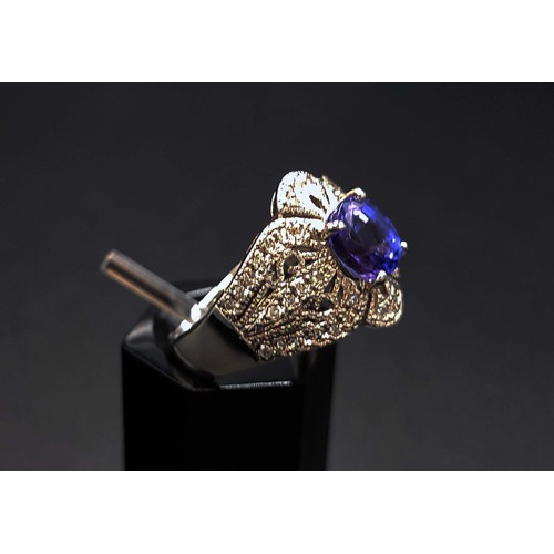 57 - PLATINUM TANZANITE AND DIAMOND SET DRESS RING, the oval tanzanite of approximately 1.52 carats, surr... 