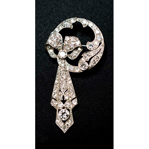 61 - ART DECO WHITE METAL AND DIAMOND ENCRUSTED BROOCH, circa 1925, in the form of a ribbon and bow, the ... 