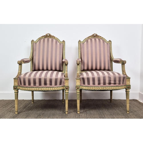 176 - FAUTEUILS, a pair, late 19th century French parcel gilt, cream and green painted with mauve striped ... 