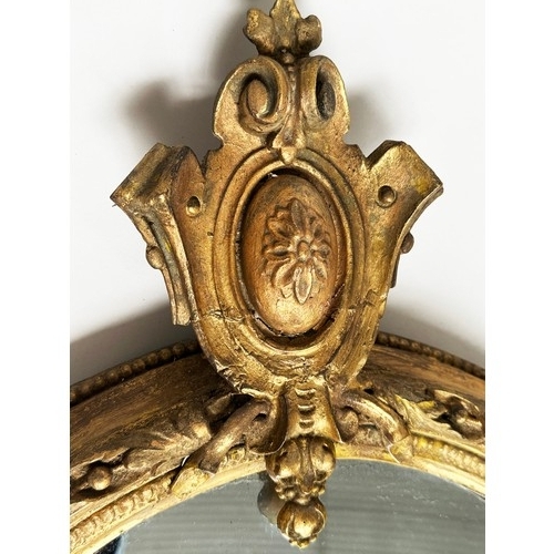 150 - WALL MIRROR, 19th century giltwood and gesso moulded having oval beaded scroll frame with shield cre... 