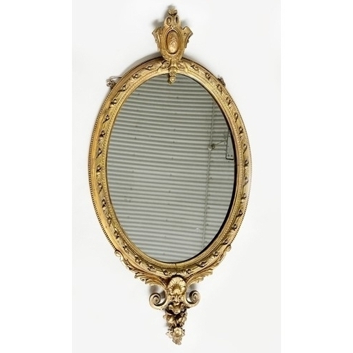 150 - WALL MIRROR, 19th century giltwood and gesso moulded having oval beaded scroll frame with shield cre... 