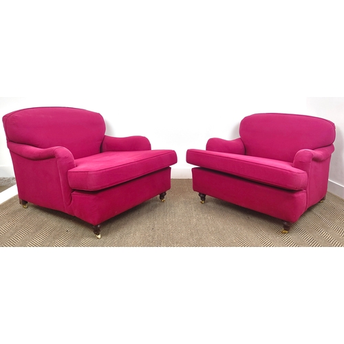 151 - HOWARD STYLE ARMCHAIRS, a pair, magenta fabric upholstered on brass castors, 77cm H x 85cm W 110cm D... 