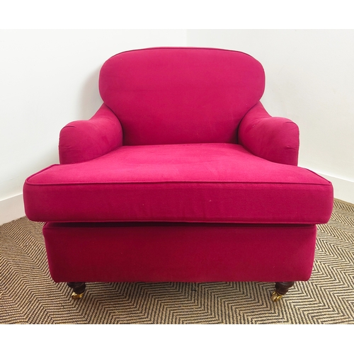 151 - HOWARD STYLE ARMCHAIRS, a pair, magenta fabric upholstered on brass castors, 77cm H x 85cm W 110cm D... 