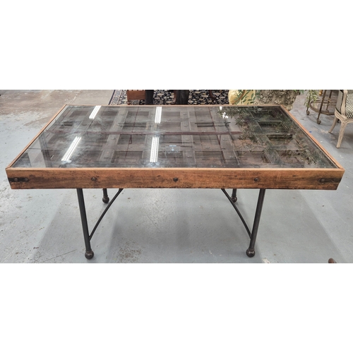 208 - DINING TABLE, Indian teak and metal studded with glazed panel door top on metal base, 79cm H x 171cm... 