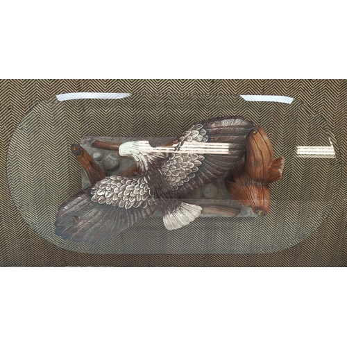 361 - LOW TABLE, shaped bevelled glass top on polychrome resin eagle support, 42cm H x 135cm W x 66cm D.