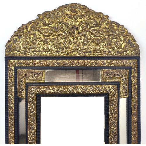 395 - LATE 19TH CENTURY DUTCH MIRROR, with repoussé brass decoration, bevelled design, ebonised wooden mou... 