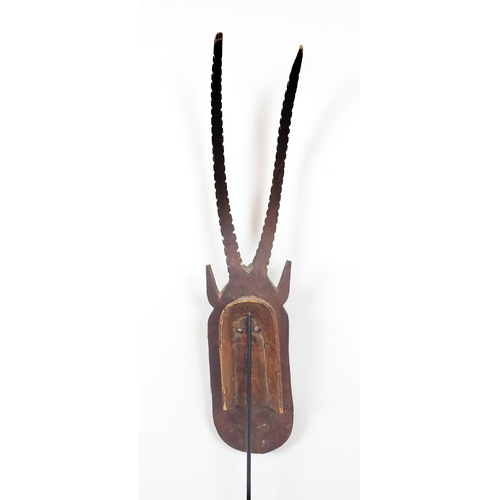 403 - AFRICAN MASK, carved wood on a metal floor stand, overall 203cm tall.