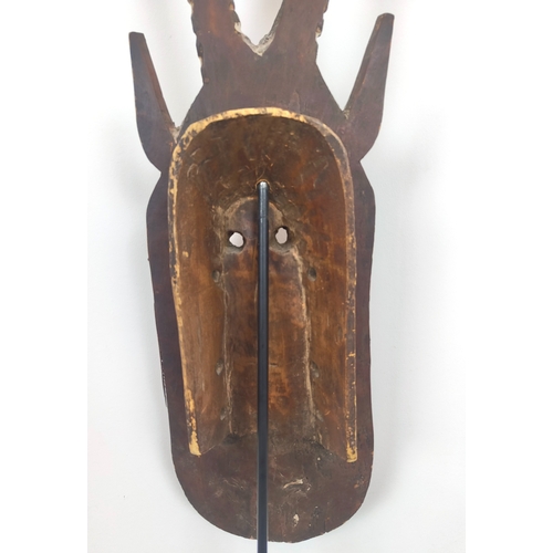 403 - AFRICAN MASK, carved wood on a metal floor stand, overall 203cm tall.