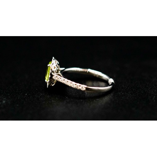 44 - PLATINUM OVAL PERIDOT AND RBC DIAMOND CLUSTER RING with diamond set shoulders. Peridot 1.12ct. Diamo... 