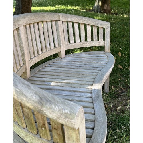 521 - BANANA GARDEN BENCH, well weathered teak of slatted construction with rounded back and arms, 158cm W... 