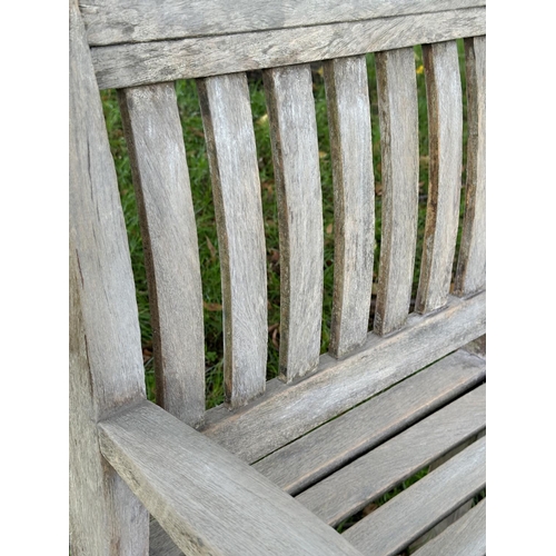 164 - GARDEN ARMCHAIRS, a pair, well weathered teak of slatted construction with curved arms, 68cm W. (2)