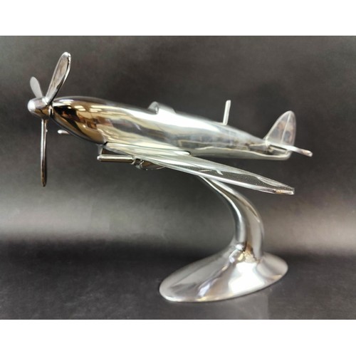 445 - SPITFIRE ORNAMENT, polished metal, on stand, 35cm H x 60cm x 50cm.