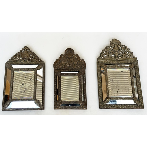 109 - WALL MIRRORS, a near pair, late/early 20th century Dutch style repoussé silvered, each with cushion ... 