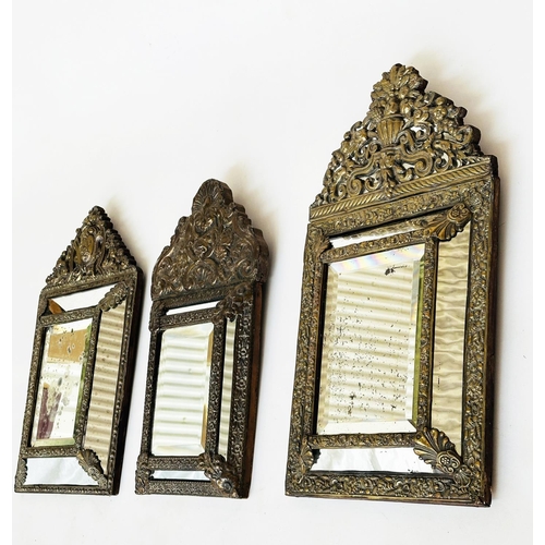 109 - WALL MIRRORS, a near pair, late/early 20th century Dutch style repoussé silvered, each with cushion ... 