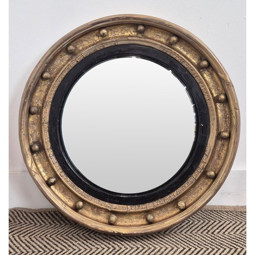 121 - CONVEX WALL MIRROR, early 19th century Regency period giltwood, the convex plate with ebonised slip ... 