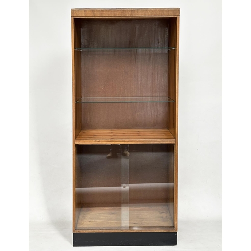 163 - DISPLAY CASE/BOOKCASE, mid 20th century oak with two adjustable glass shelves above a two sliding do... 