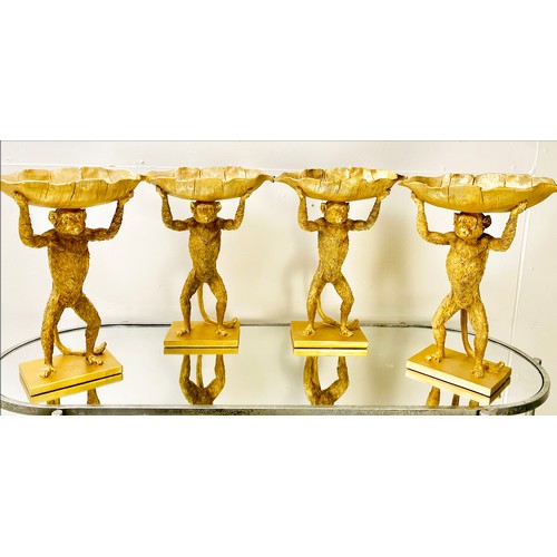 384 - MONKEY TAZZAS, a set of four, gilt resin each with palm leaf dishes, 35cm H x 28cm x 11cm. (4)