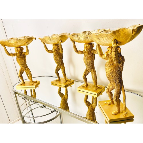 384 - MONKEY TAZZAS, a set of four, gilt resin each with palm leaf dishes, 35cm H x 28cm x 11cm. (4)