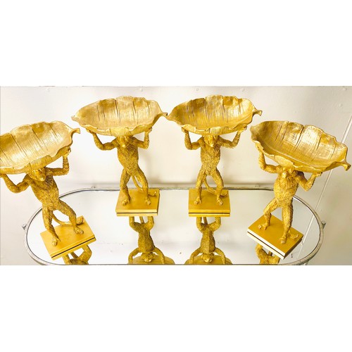 384 - MONKEY TAZZAS, a set of four, gilt resin each with palm leaf dishes, 35cm H x 28cm x 11cm. (4)