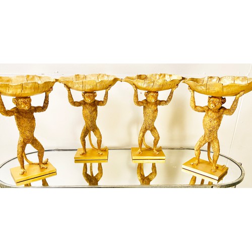 384 - MONKEY TAZZAS, a set of four, gilt resin each with palm leaf dishes, 35cm H x 28cm x 11cm. (4)