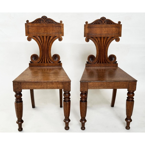 177 - HALL CHAIRS, a pair, late Regency oak each with scroll back, panel seat and facetted front supports,... 