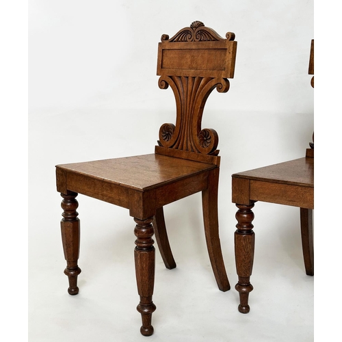 177 - HALL CHAIRS, a pair, late Regency oak each with scroll back, panel seat and facetted front supports,... 