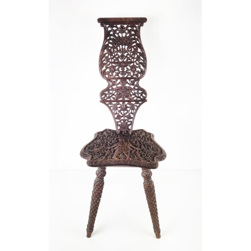 373 - MILKING CHAIR, early 20th century Indian hardwood and all over carved, 76cm H x 31cm W.