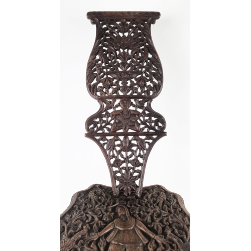 373 - MILKING CHAIR, early 20th century Indian hardwood and all over carved, 76cm H x 31cm W.