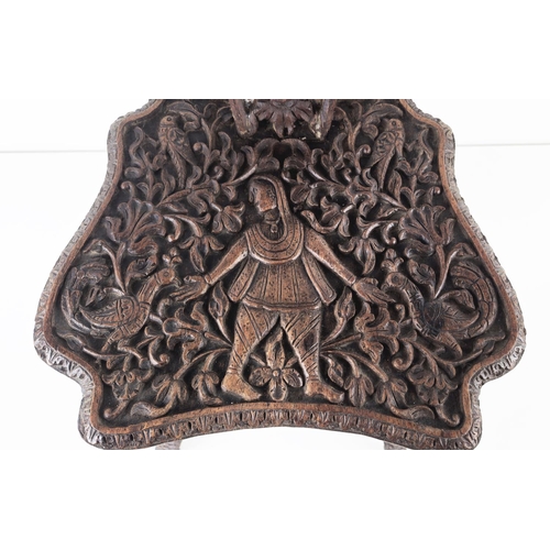 373 - MILKING CHAIR, early 20th century Indian hardwood and all over carved, 76cm H x 31cm W.