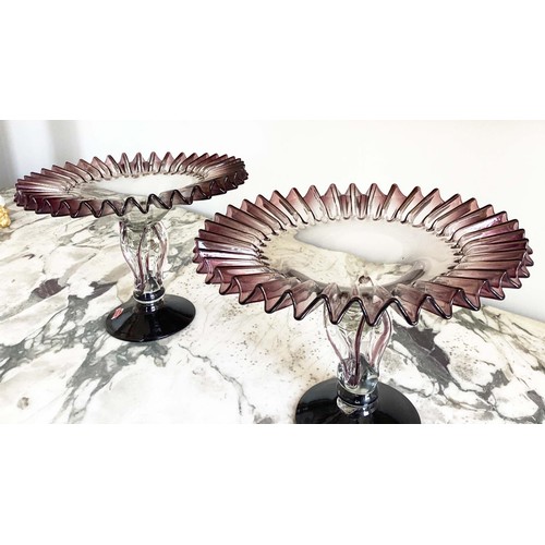 67 - MURANO GLASS TAZZE, a pair, ruffle rimmed circa 1950, clear and aubergine on pierced stem and spread... 