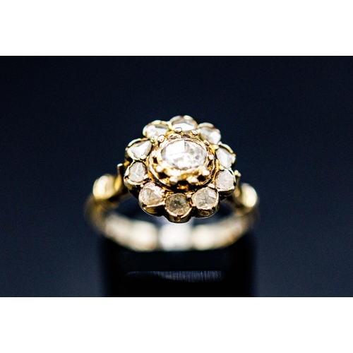 136 - A YELLOW METAL DIAMOND CLUSTER RING, probably 18th century, set with a central rose cut stone of app... 