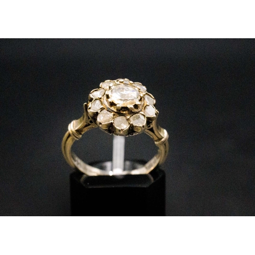 136 - A YELLOW METAL DIAMOND CLUSTER RING, probably 18th century, set with a central rose cut stone of app... 