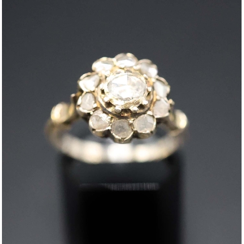 136 - A YELLOW METAL DIAMOND CLUSTER RING, probably 18th century, set with a central rose cut stone of app... 