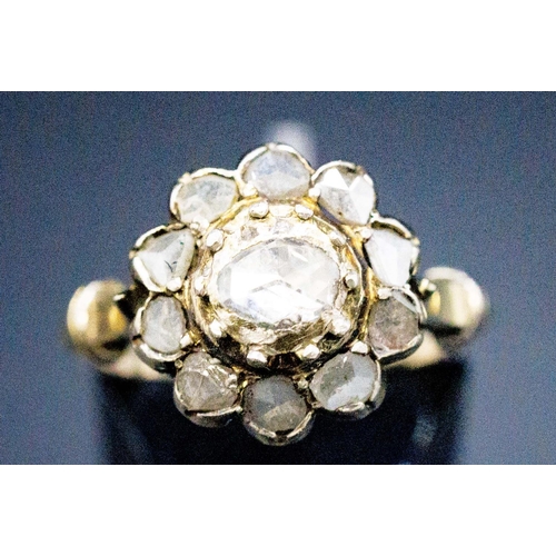 136 - A YELLOW METAL DIAMOND CLUSTER RING, probably 18th century, set with a central rose cut stone of app... 