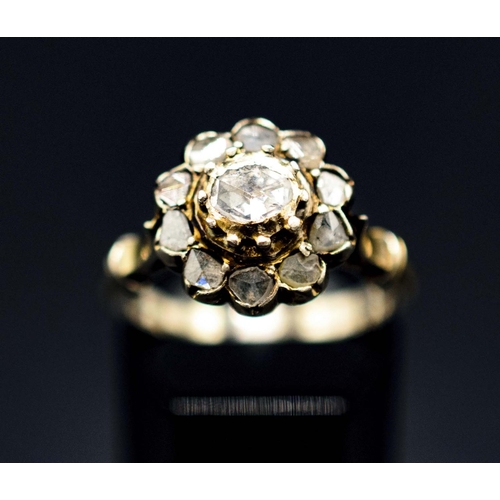 136 - A YELLOW METAL DIAMOND CLUSTER RING, probably 18th century, set with a central rose cut stone of app... 