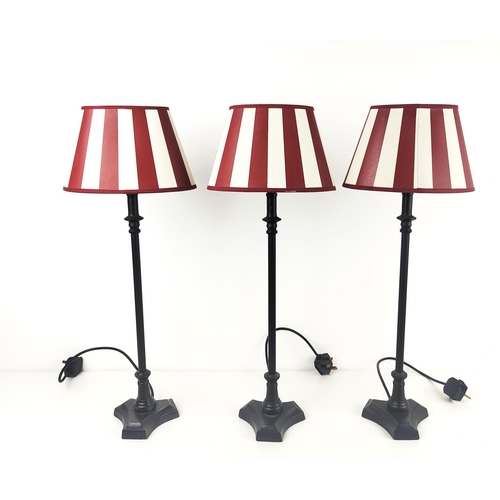 380 - TABLE LAMPS, three, with metal columns, and red and white shades, each overall 67cm tall. (3)