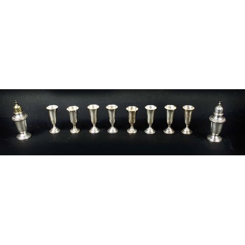 65 - STERLING SILVER SHOT GLASSES, a set of eight, together with a pair of silver salt and pepper pots, 2... 