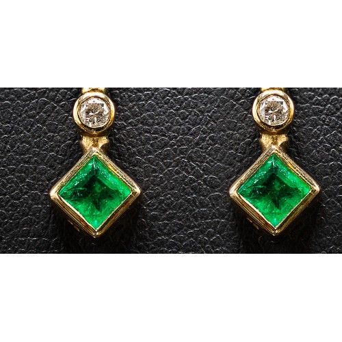 128 - A PAIR OF 9CT GOLD EMERALD AND DIAMOND DROP EARRINGS, each with a square cut emerald individually mo... 