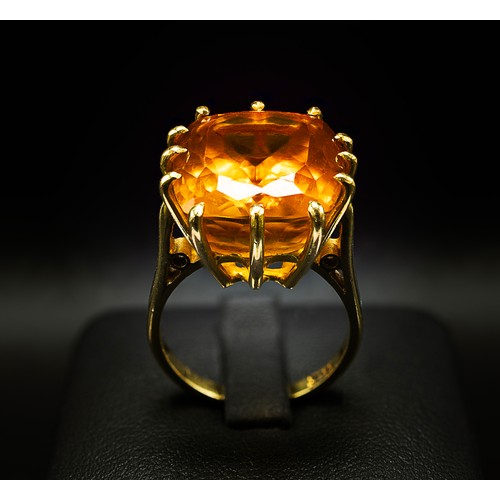 129 - A 18CT YELLOW GOLD AND ORANGE STONE DRESS RING, the large orange mixed cut stone possibly a spinel, ... 