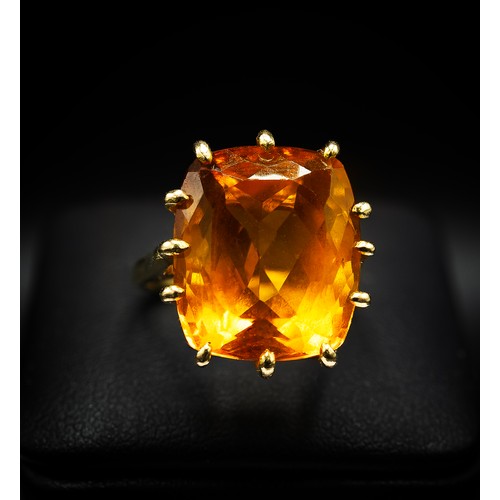 129 - A 18CT YELLOW GOLD AND ORANGE STONE DRESS RING, the large orange mixed cut stone possibly a spinel, ... 