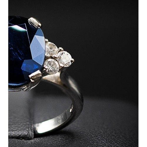 132 - AN 18CT WHITE GOLD SAPPHIRE AND DIAMOND RING, the large oval mixed cut sapphire flanked by six round... 