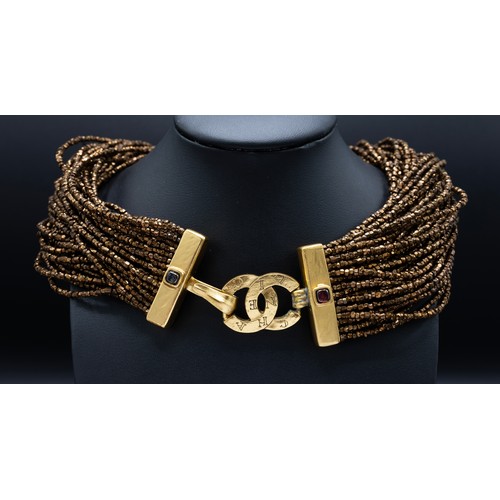 43 - CHANEL CHOKER, multi rows of iridescent bronze beads, the centre features a large gilt metal Byzanti... 