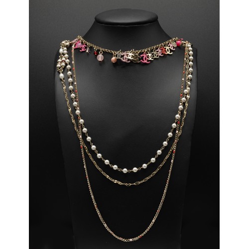 44 - CHANEL NECKLACE, four rows gold tone chain, with pearl beads and different tones of pink CC charms a... 